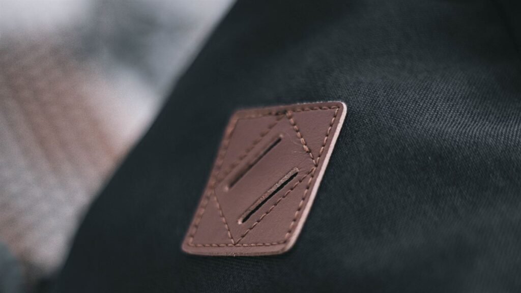 Patch de cuir cousu sur le tissu sombre d'un vêtement technique