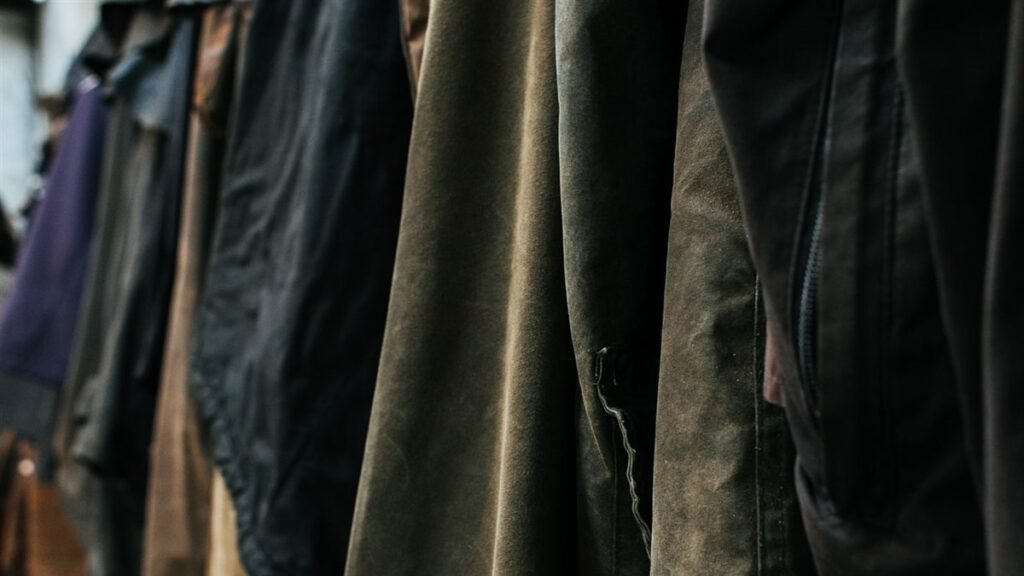 Portant de vestes d'extérieur en coton huilé et nylon aux teintes sombres